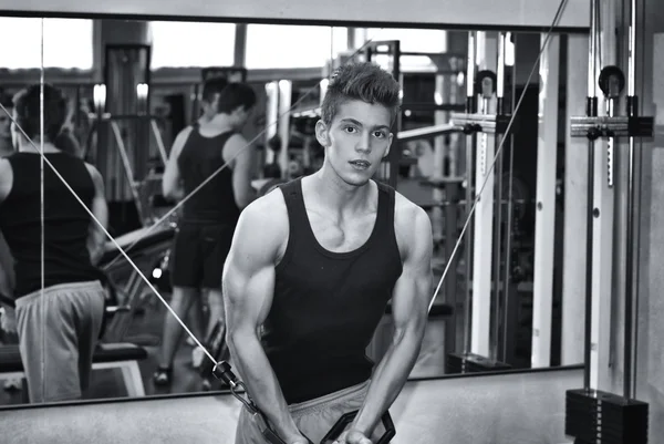 Teen bodybuilder working out with gym equipment — Stock Photo, Image