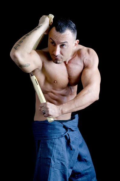 Muscular martial arts man shirtless using nunchuks — Stock Photo, Image
