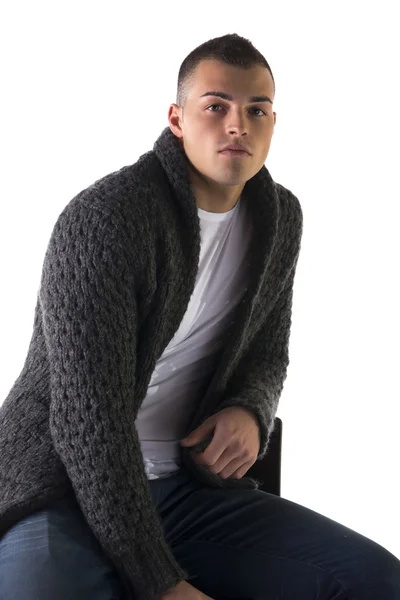 Όμορφος νεαρός άνδρας, που κάθεται στο σκαμνί με μαλλί πουλόβερ και τζιν — Φωτογραφία Αρχείου