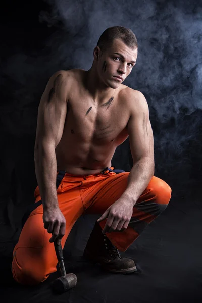 Sexy shirtless construction worker with hammer, kneeling — Stok Foto