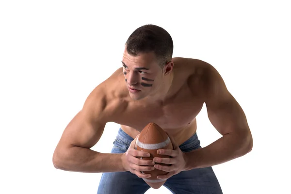 Красивый, серьезный молодой человек без рубашки, держа американский футбол — стоковое фото