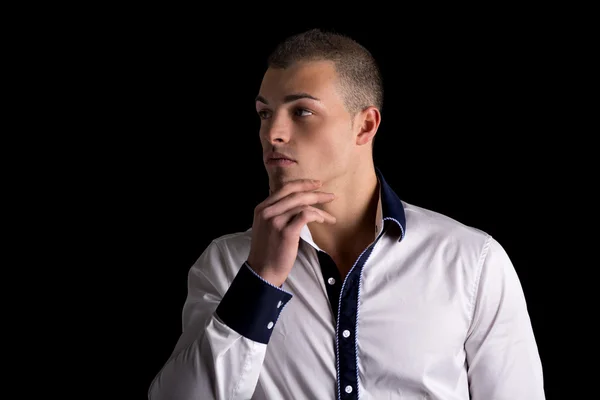Attraktiver junger Mann weiß Shirt, Hand am Kinn — Stockfoto