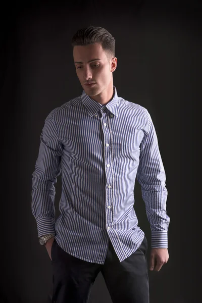 Homem jovem sorridente na camisa listrada, olhando para baixo — Fotografia de Stock