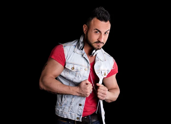 Homme musclé avec gilet jeans (gilet) et des écouteurs autour du cou — Photo