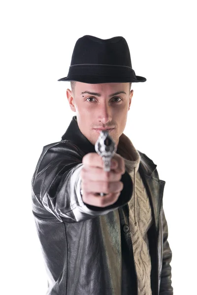 Young man pointing gun at camera, wearing hat and leather jacket — kuvapankkivalokuva