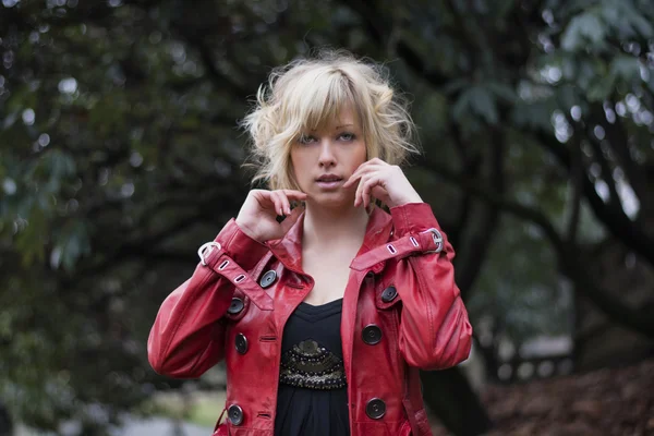 Aantrekkelijke jonge vrouw met rood lederen jas — Stockfoto