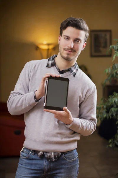 Hezký mladý muž doma s tabletem PC v ruce — Stock fotografie