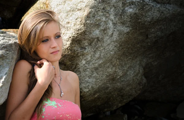 Pretty blue eyed, brunette girl in bikini against rocks — Stock Photo, Image