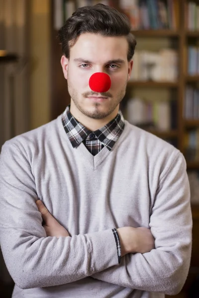 Sérieux jeune homme au nez de clown rouge — Photo