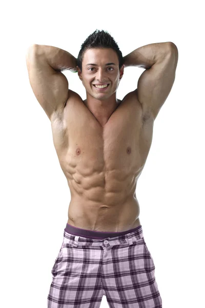 Svalnatý mladý kulturista ukazuje biceps a roztržené břišní svaly — Stock fotografie