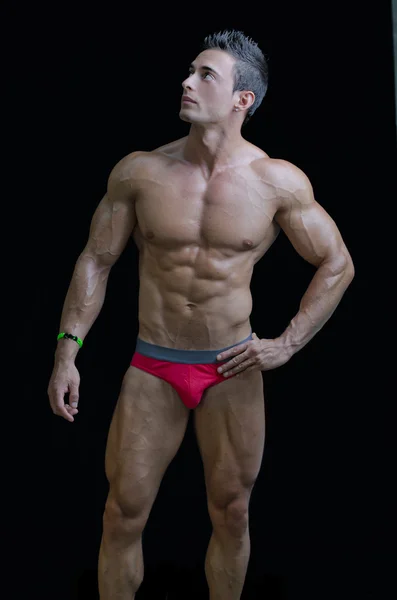 Muscular young bodybuilder in relaxed pose, looking up — Fotografia de Stock