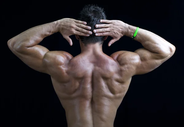 Volta de jovem fisiculturista muscular, mãos atrás da cabeça — Fotografia de Stock