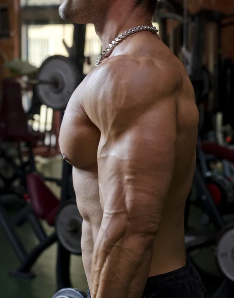 Man tränar på gym, sidoutsikt över bröstet, pecs och arm — Stockfoto