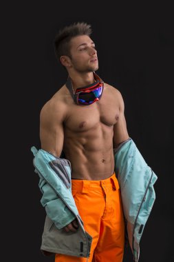 kas genç erkek kayakçı veya ceketini alarak snowboarder