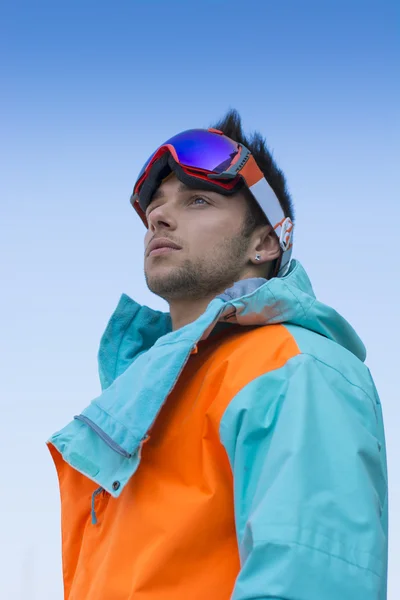 Amistoso esquiador atractivo o snowboarder contra el cielo azul —  Fotos de Stock