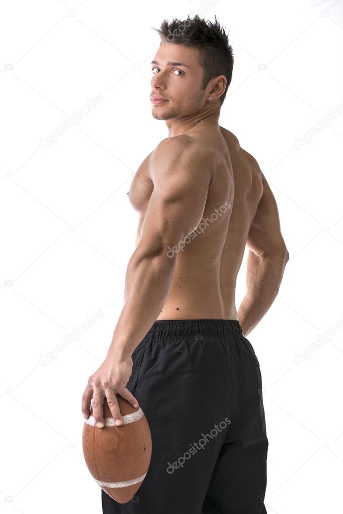 Muscular american football player standing with ball in hand