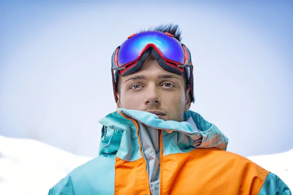 Przyjazny, atrakcyjny narciarz lub snowboardzista przeciwko błękitnemu niebu — Zdjęcie stockowe