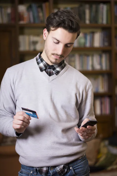 Aantrekkelijke jonge man online winkelen op mobiele telefoon — Stockfoto