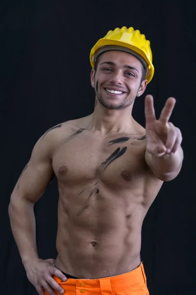 Muscular young construction worker shirtless doing peace sign — Stock Photo, Image