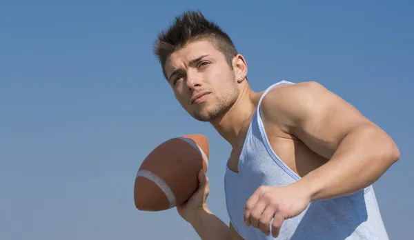 Muscular american football player ready to throw ball — Stock Photo, Image