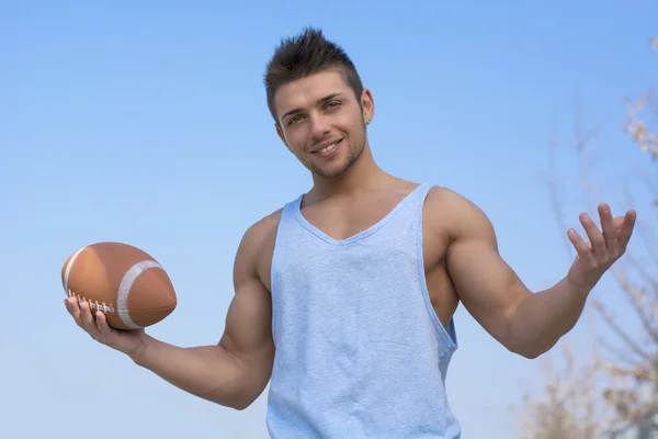 Jugador de fútbol americano muscular con la bola en la mano, brazos abiertos — Foto de Stock