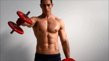 genç yakışıklı erkek vücut geliştirmeci eğitim omuz dumbbells ile