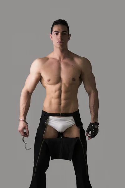 Muscular shirtless young man with handcuffs and studded glove — Stock Photo, Image