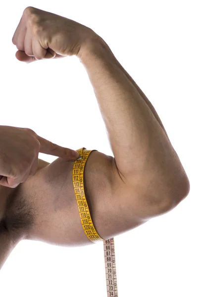 Мускулистые рубашки молодой человек, измерения руку с рулеткой — стоковое фото