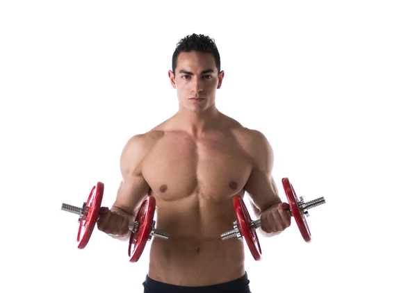 Jovem sem camisa muscular exercitando bíceps com halteres — Fotografia de Stock