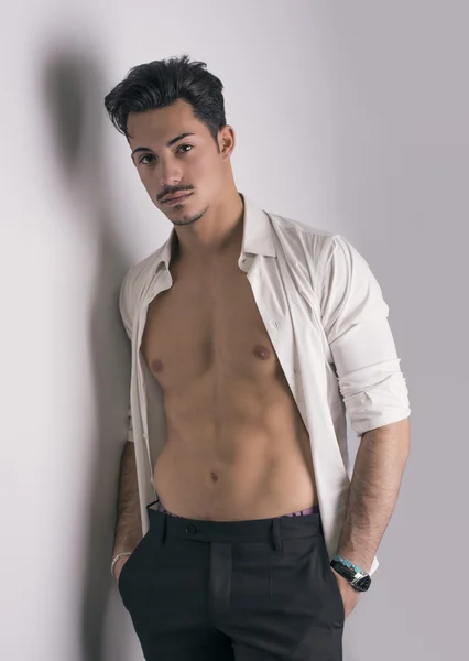 Hombre joven atractivo elegante con camisa blanca abierta en el torso desnudo — Foto de Stock