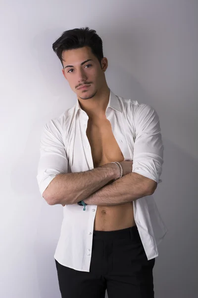 Hombre joven atractivo elegante con camisa blanca abierta en el torso desnudo — Foto de Stock