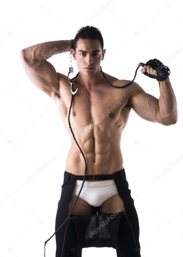 Muscular shirtless young man with handcuffs, whip and glove