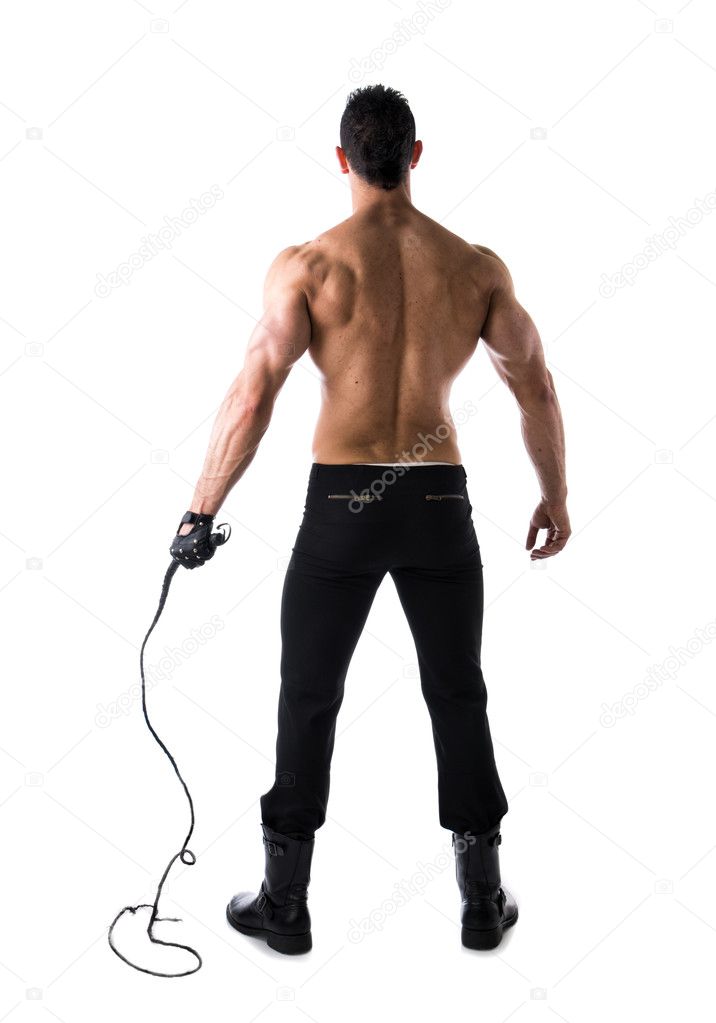 Full body shot of muscular man with whip and leather glove, seen from the back