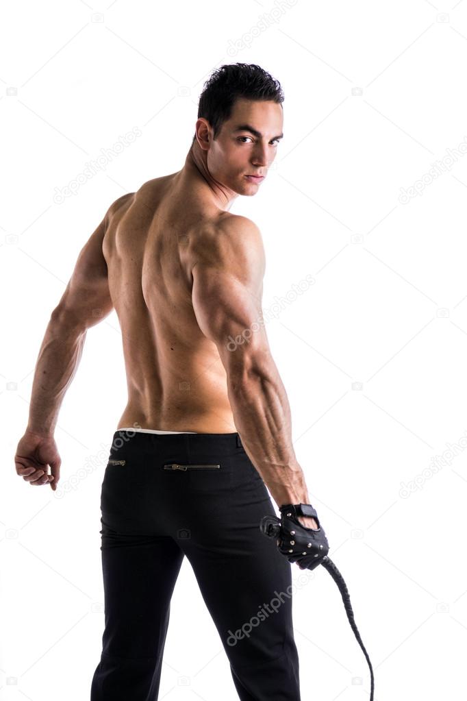 Muscular shirtless young man with whip and studded glove