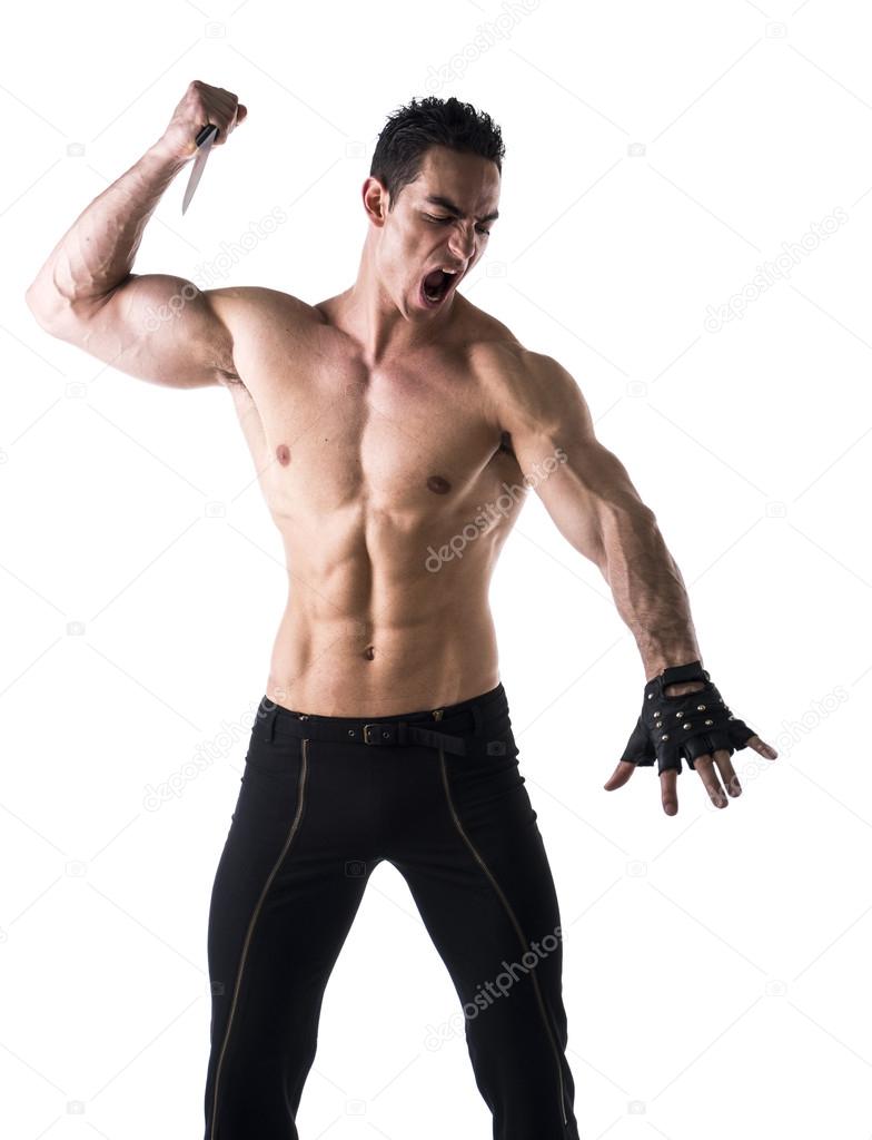 Muscular young man holding big knife ready to stab