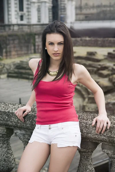 Atraktivní mladá žena na kamenné sloupky — Stock fotografie
