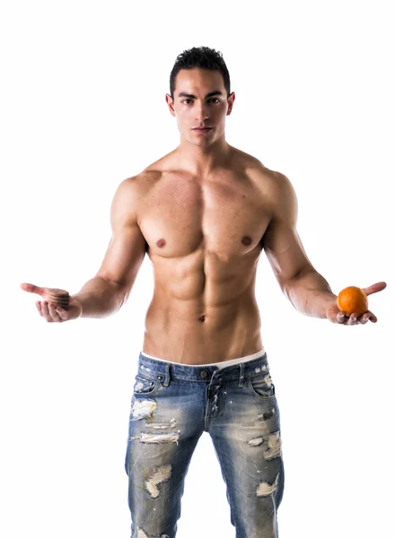 Muscular shirtless young man deciding: fruit or cookies — Stock Photo, Image