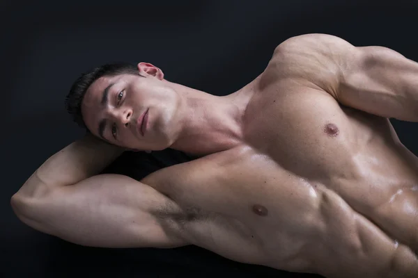 Jovem atraente no chão com o corpo rasgado muscular — Fotografia de Stock