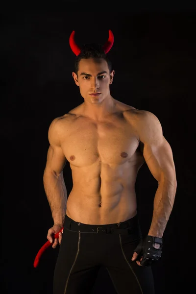 Félmeztelen izmos testépítő férfi öltözött ördög jelmez — Stock Fotó
