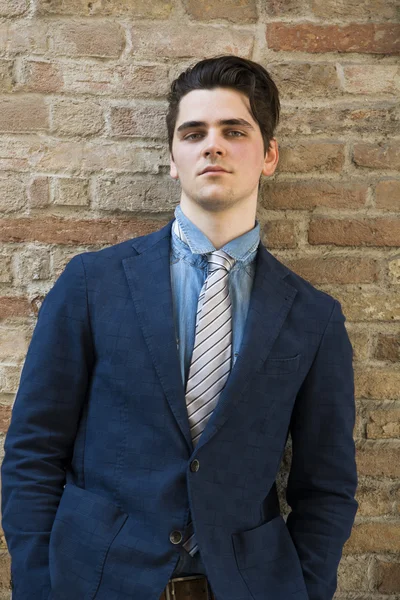 Joven guapo en traje contra la pared de ladrillo —  Fotos de Stock