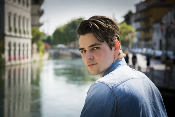 Young man wearing denim shirt on city bridge — Stock Photo, Image