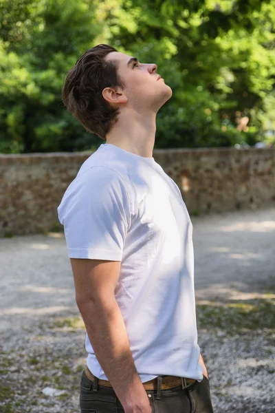 Joven guapo en el parque mirando hacia arriba — Foto de Stock