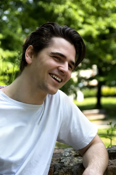 Attractive young man smiling in nature environment — Stock Photo, Image