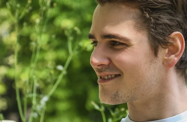 Headshot atrakcyjny młody człowiek uśmiechający się w charakter środowiska — Zdjęcie stockowe