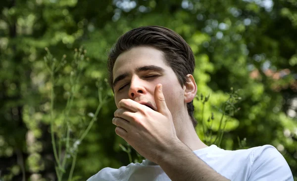 Bored or tired young man yawning - Stock-foto