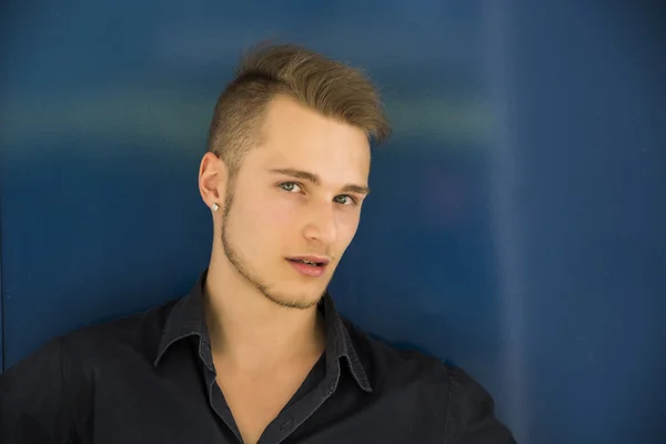 Séduisante jeune homme blond sur mur bleu — Photo