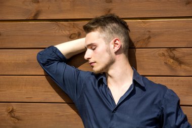 sarışın yakışıklı genç dışında ahşap duvara karşı