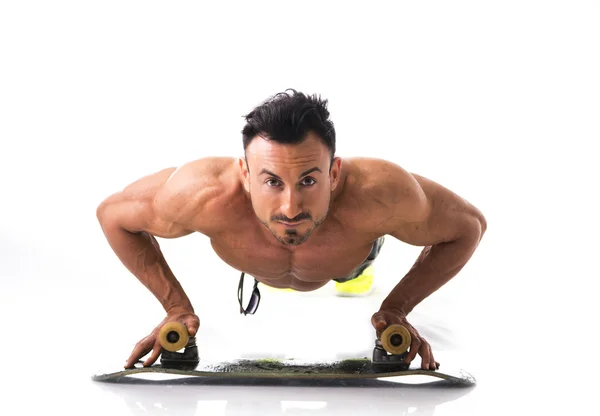 Shirtless muscular man on the floor with skateboard — Stock Photo, Image