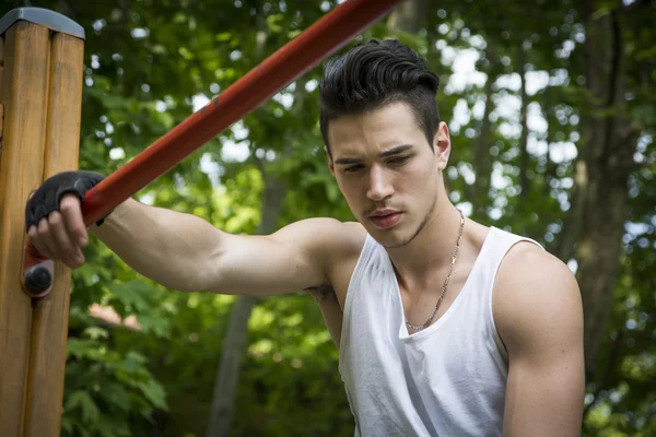 Handsome young man exercising in outdoor gym in park — Stock Photo, Image