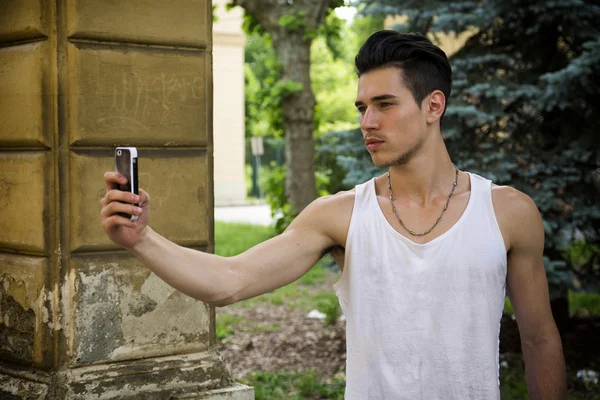 Ung man leende och med "selfie" med mobiltelefons kamera — Stockfoto